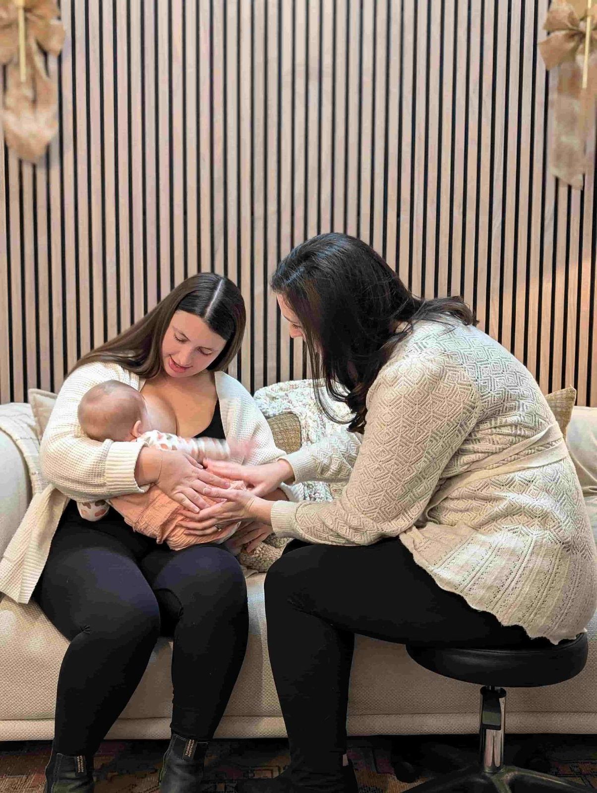 Lactation consultant providing compassionate breastfeeding support to parent and baby